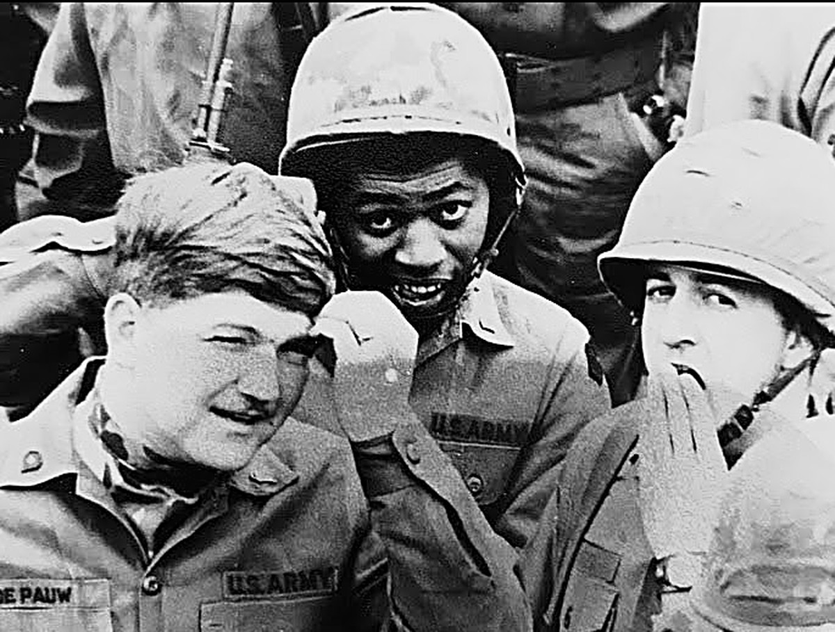 Three young U.S. Army soldiers in helmets and fatigues, black-and-white archival photo